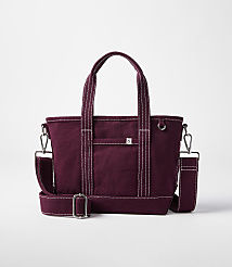 A burgundy canvas tote bag with white stitching and a detachable shoulder strap rests on a white background. carousel Product Image 1