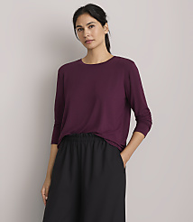 A woman in a plum-colored shirt and black pants stands against a plain gray background. carousel Product Image 2