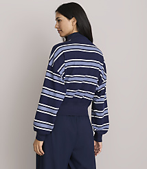 A woman in a striped sweatshirt and dark pants stands against a plain gray background. carousel Product Image 3