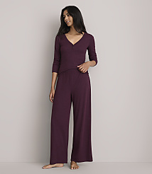 A woman in burgundy pajamas stands against a plain gray background. carousel Product Image 1