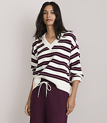 A woman in a striped sweater and maroon sweatpants stands against a plain, light gray background. carousel Product Image 1