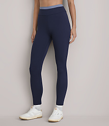 A person stands in dark blue leggings and white sneakers against a plain white background. carousel Product Image 3