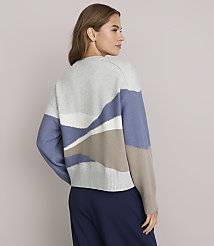 A woman in a patterned sweater stands against a plain background. carousel Product Image 3