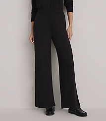 A person stands in wide-legged black pants and black shoes against a plain white background. carousel Product Image 2
