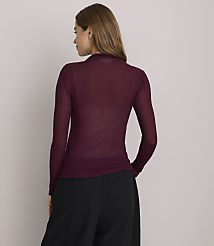 A woman in a sheer burgundy turtleneck and black pants stands against a plain white background. carousel Product Image 3