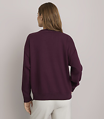 A woman in a maroon sweatshirt stands against a plain, light gray background. carousel Product Image 3