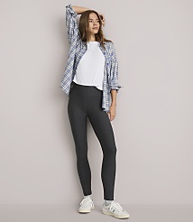 A woman in a white t-shirt, grey leggings, and a blue plaid shirt stands against a plain white background. carousel Product Image 1