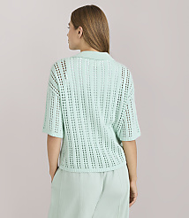 A woman in a light green collared knit shirt and matching pants stands against a plain white background. carousel Product Image 3