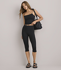 A woman in a black tank top and capri leggings stands against a plain white background, carrying a black tote bag. carousel Product Image 1