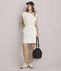 A young woman in a cream-colored dress stands against a plain white background. carousel Product Image 2