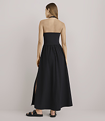 A woman in a black halter maxi dress with a slit stands against a plain white background. carousel Product Image 3