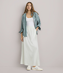 A woman in a white tank top, a green patterned shirt, and a long white skirt stands against a plain white background. carousel Product Image 1