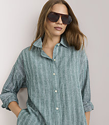 A woman in a striped pajama set stands against a plain white background. carousel Product Image 2