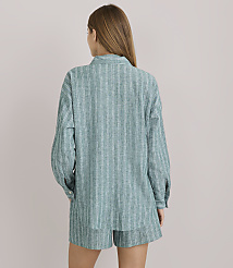 A woman in a striped pajama set stands against a plain white background. carousel Product Image 3