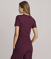 A woman in a maroon t-shirt and pants stands with her back to the camera against a plain gray background. carousel Product Image 3