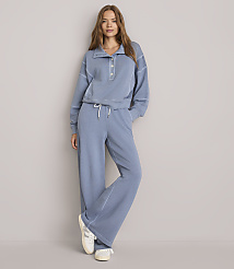 A woman in a blue loungewear set stands against a plain gray background. carousel Product Image 1