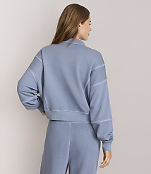 A woman in a blue sweatshirt and pants stands against a plain white background. carousel Product Image 3