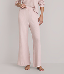 A person stands barefoot in pink waffle-knit pajama pants and a matching top against a plain white background. carousel Product Image 2