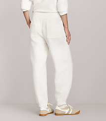 A person wearing cream-colored waffle-knit sweatpants and sneakers stands against a plain white background. carousel Product Image 3