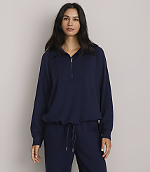 A woman in a navy blue quarter-zip sweatshirt and matching pants stands against a plain gray background. carousel Product Image 1