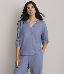 A woman in a blue waffle-knit top and pants stands against a plain gray background. carousel Product Image 1