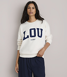A woman in a cream sweatshirt with "LOU & GREY" printed on it stands against a plain, light gray background. carousel Product Image 1
