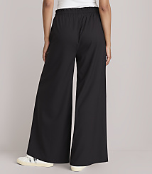 A person wearing black wide-leg pants and white sneakers stands against a plain, light gray background. carousel Product Image 3