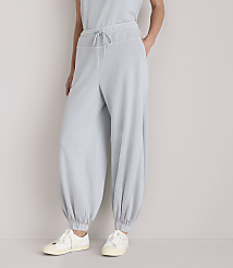 A person stands in light gray, baggy pants and white sneakers against a plain white background. carousel Product Image 2