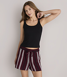 A young woman in a black tank top and striped shorts stands against a plain white background. carousel Product Image 1