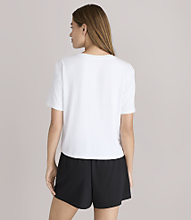 A woman in a white t-shirt and black shorts stands against a plain white background. carousel Product Image 3