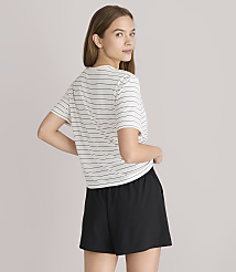 A young woman in a striped t-shirt and black shorts stands against a plain gray background. carousel Product Image 3
