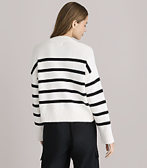A woman in a white and black striped sweater stands against a plain white background. carousel Product Image 3