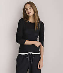 A woman in a black long-sleeved shirt and black pants stands against a plain white background. carousel Product Image 1
