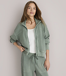 A woman in a green zip-up jacket and matching pants stands against a plain white background. carousel Product Image 1