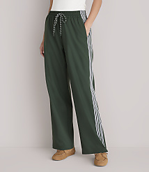 A person stands in dark green athletic pants with white stripes down the sides, wearing brown loafers against a plain white background. carousel Product Image 2