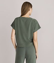 A woman in a green t-shirt and pants stands against a plain gray background. carousel Product Image 3
