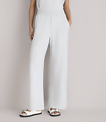 A person wearing light gray wide-leg sweatpants and white sandals stands against a plain white background. carousel Product Image 2