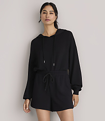 A woman in a black hoodie and shorts stands against a plain white background. carousel Product Image 1
