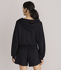 A woman in a black hoodie and shorts stands against a plain white background. carousel Product Image 3