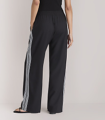 A person wearing black wide-leg pants with white stripes stands against a plain white background. carousel Product Image 3