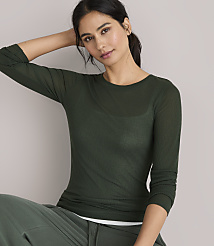 A woman in a green sweater and pants stands against a plain gray background. carousel Product Image 2
