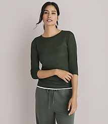 A woman in a dark green, sheer, long-sleeved shirt and green pants poses against a plain white background. carousel Product Image 1