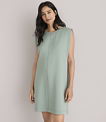 A woman in a green dress and white sandals stands against a plain white background with a striped sweater tied around her waist. carousel Product Image 1