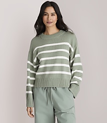 A woman in a green and white striped sweater and light green pants stands against a plain gray background. carousel Product Image 1