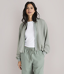 A woman in a light green bomber jacket and matching pants stands against a plain white background. carousel Product Image 1