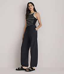 A woman in a striped tank top and baggy pants stands against a plain white background. carousel Product Image 1