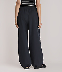 A person wearing dark, wide-leg pants and sandals stands against a plain white background. carousel Product Image 3