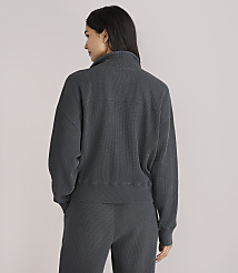 A woman in a dark grey ribbed quarter-zip sweatshirt and matching pants stands against a plain white background. carousel Product Image 3