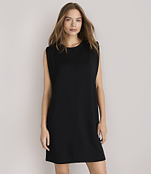 A woman in a black shift dress stands against a plain white background. carousel Product Image 1
