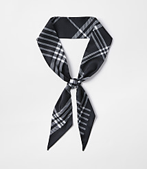 A black and white plaid scarf is tied in a knot in the foreground against a plain white background. carousel Product Image 1